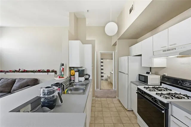 a kitchen with stainless steel appliances granite countertop a sink dishwasher stove and refrigerator