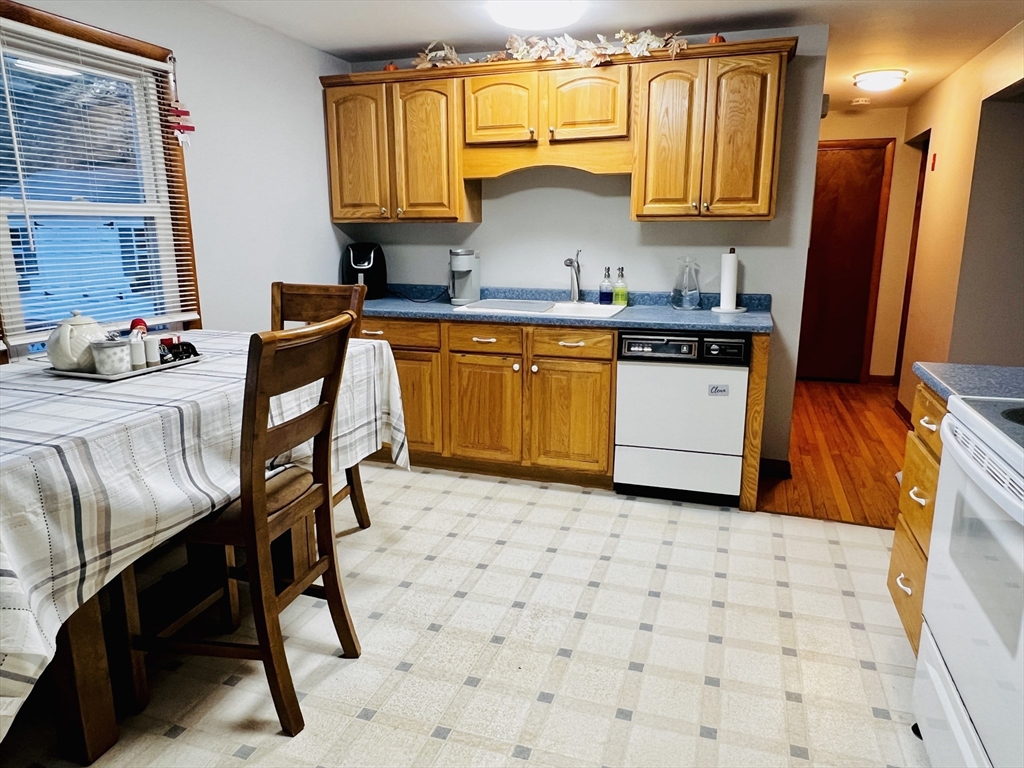 62 Arnold Road Sturbridge, MA 01518 - Photo 7 of 28 a kitchen with stainless steel appliances a stove a sink a microwave a dining table and chairs