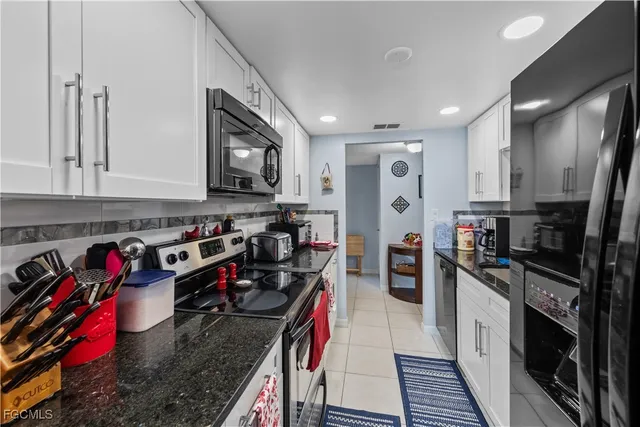 a kitchen with stainless steel appliances granite countertop a refrigerator stove and sink