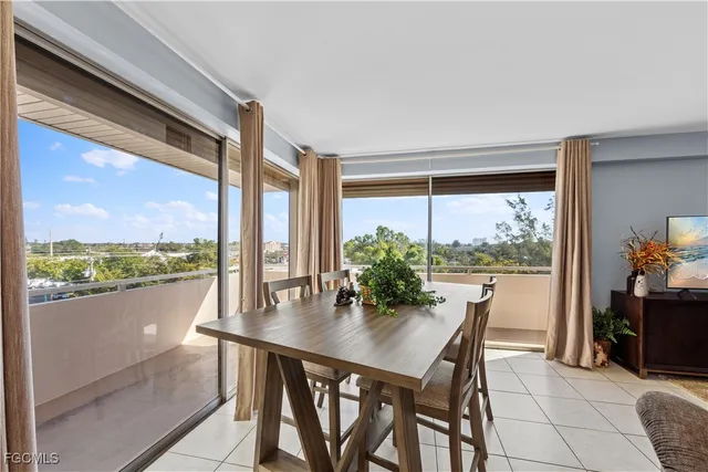 a dining room with furniture and a floor to ceiling window