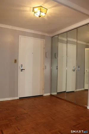 an empty room with wooden floor and bathroom view