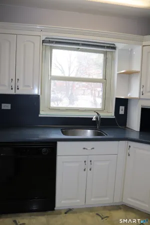 a kitchen with granite countertop white cabinets and sink