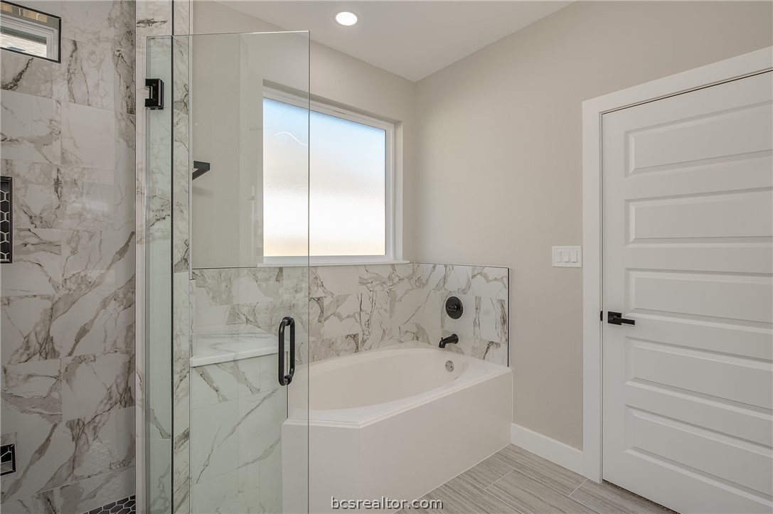 2908 GOLDBERG Drive Bryan, TX 77808 - Photo 32 of 44 Master bathroom retreat features soaking tub, natural light, walk in shower with decorative ceramic tile and glass shower enclosure.
