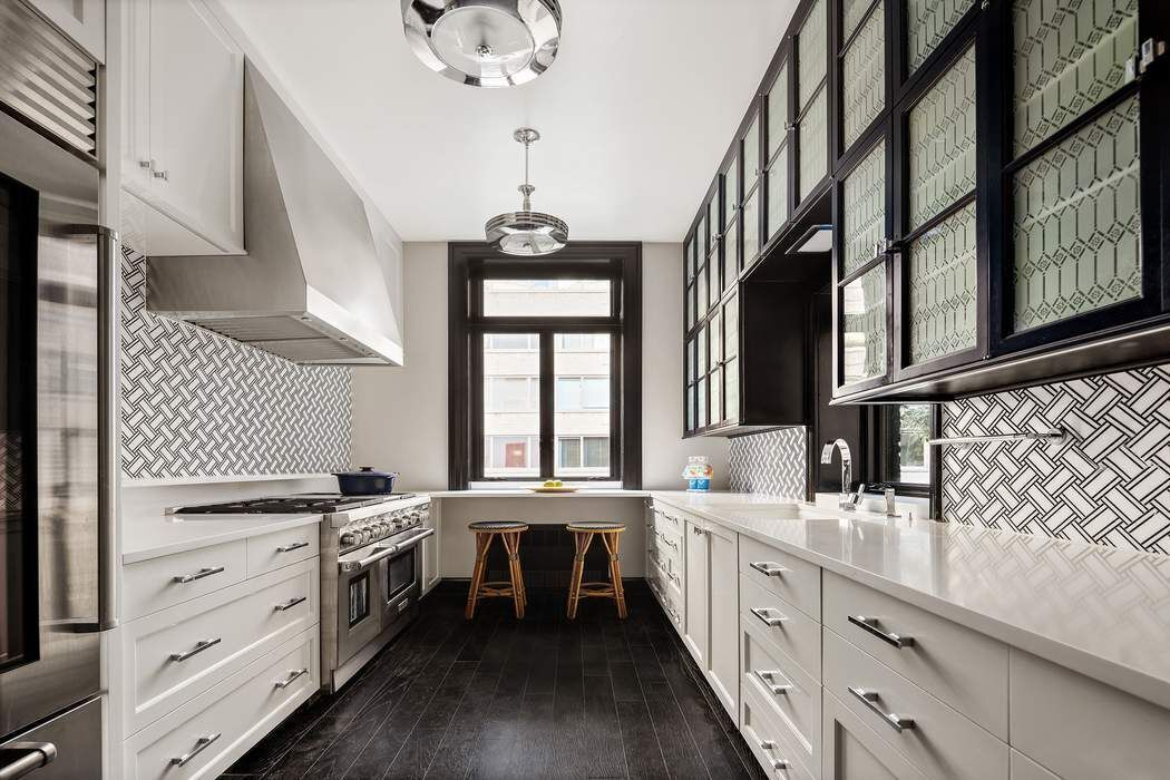 314 West 71st Street Manhattan, NY 10023 - Photo 11 of 19 a kitchen with stainless steel appliances kitchen island granite countertop a sink a stove and cabinets
