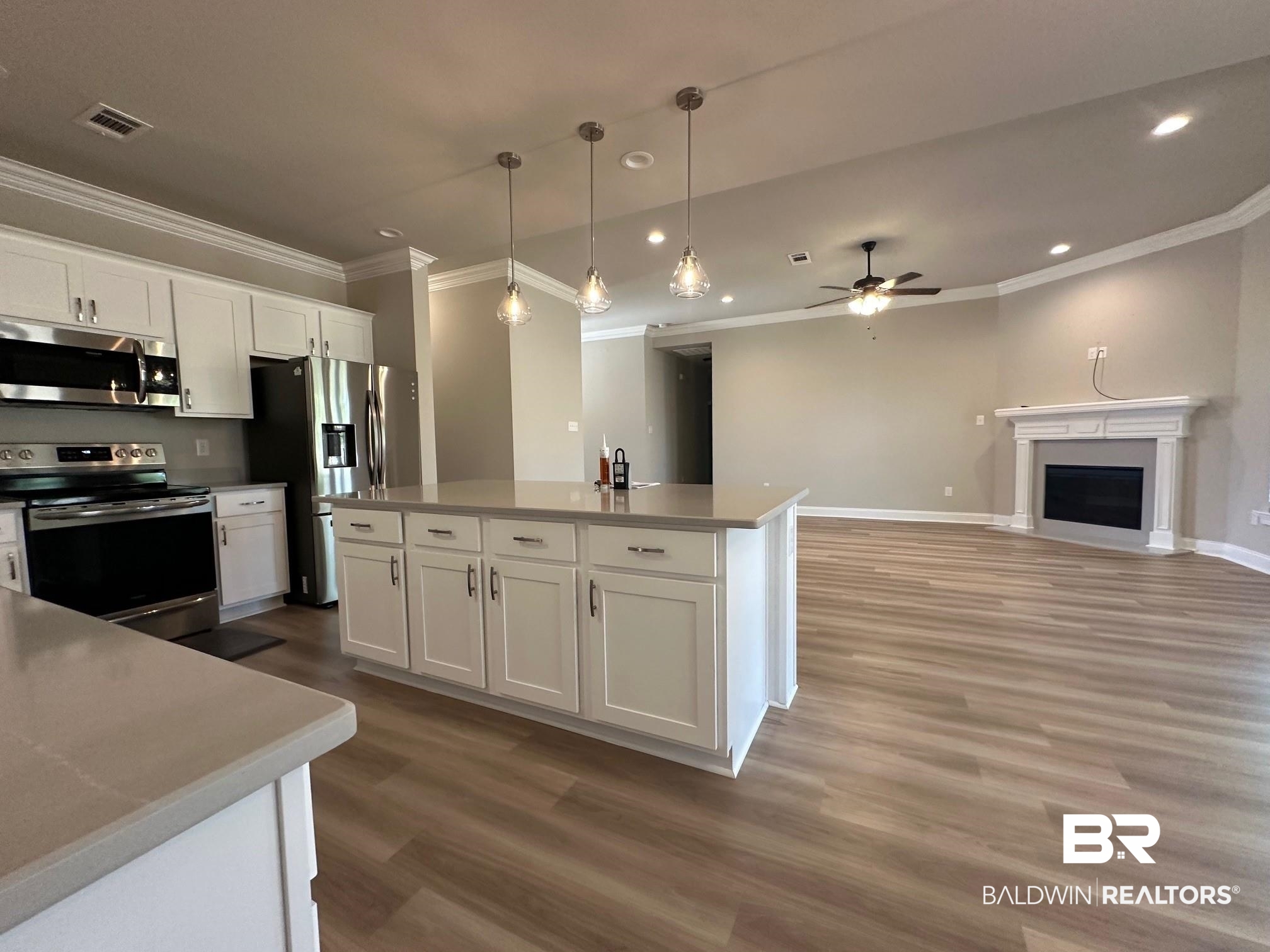 1009 Ruisseau Drive Foley, AL 36535 - Photo 33 of 55 Kitchen with hardwood / wood-style floors, appliances with stainless steel finishes, white cabinetry, pendant lighting, and a center island