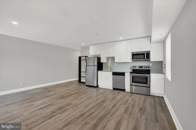 a kitchen with a refrigerator sink and white cabinets