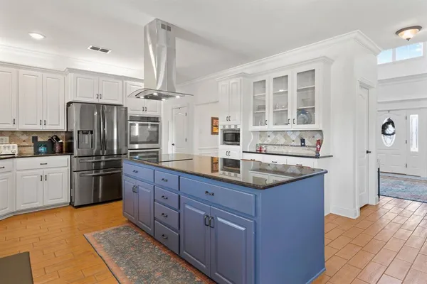 a kitchen with stainless steel appliances kitchen island granite countertop a table and chairs in it