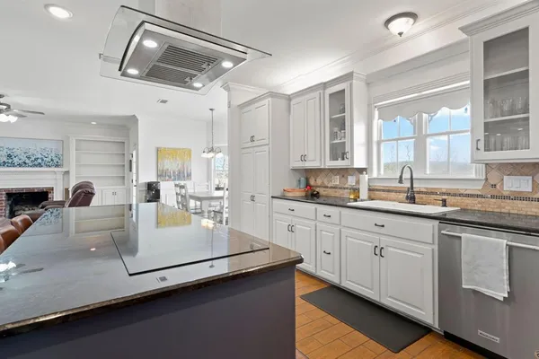 a kitchen with stainless steel appliances white cabinets and wooden floors