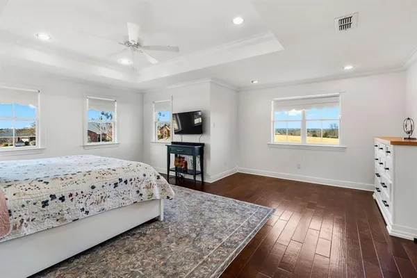 a bedroom with a large bed and a chandelier