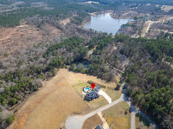 a aerial view of a house with a yard and large trees