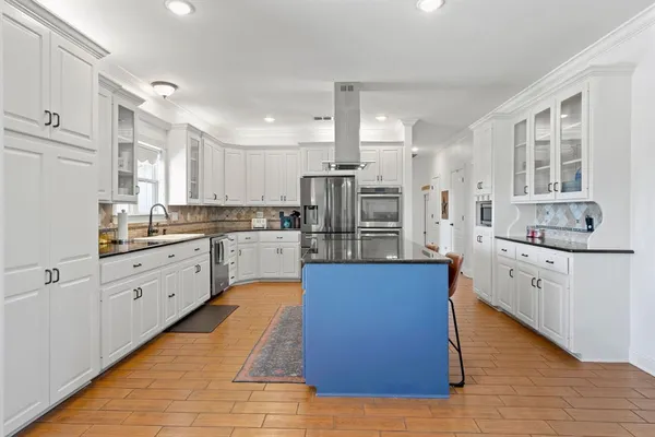 a kitchen with stainless steel appliances granite countertop a sink a stove and a refrigerator