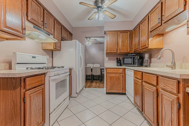 a kitchen with stainless steel appliances granite countertop a refrigerator a stove top oven a sink and dishwasher