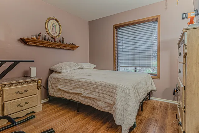 a bedroom with a bed and closet with wooden floor