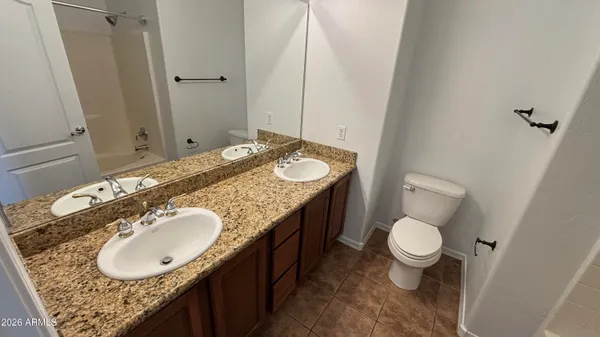 a bathroom with a granite countertop toilet a sink and a mirror
