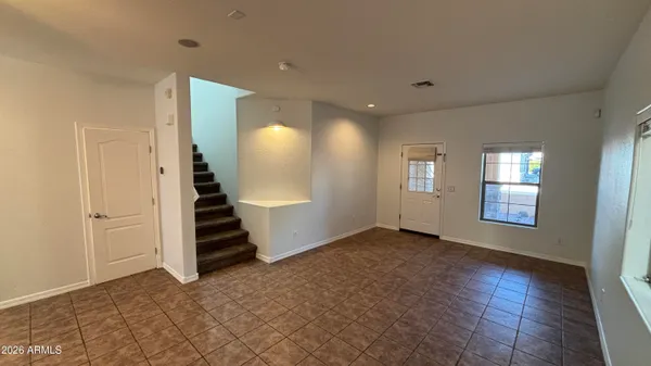an empty room with wooden floor and stairs