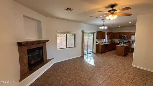 a view of a kitchen with a stove cabinets a fireplace and a ceiling fan
