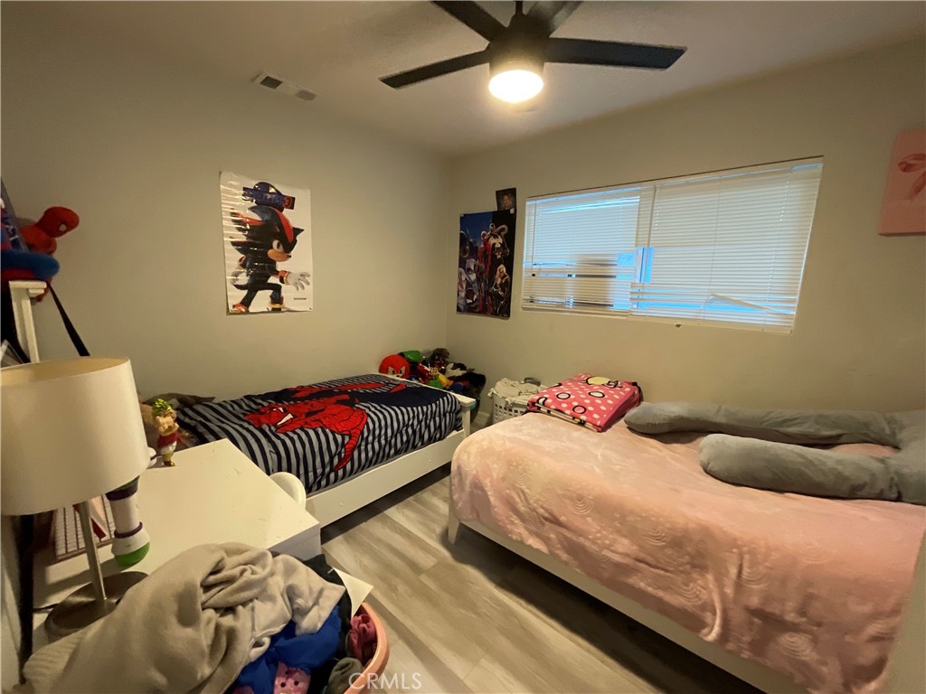 114 South Acacia Avenue Rialto, CA 92376 - Photo 11 of 21 a bedroom with a bed and wooden floor