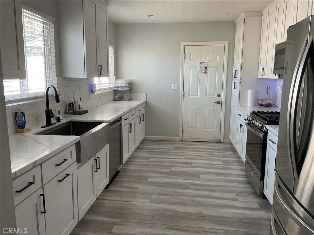 114 South Acacia Avenue Rialto, CA 92376 - Photo 2 of 21 a kitchen with stainless steel appliances a sink stove and refrigerator
