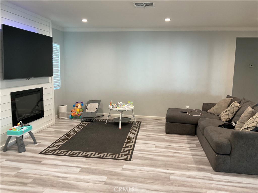 114 South Acacia Avenue Rialto, CA 92376 - Photo 3 of 21 a living room with furniture a flat screen tv and a fireplace