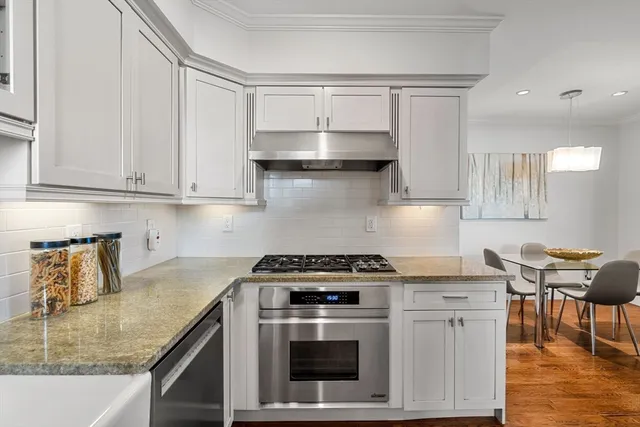 a kitchen with granite countertop a stove a sink and a granite counter tops