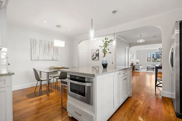 a kitchen with stainless steel appliances granite countertop a stove and a wooden floors