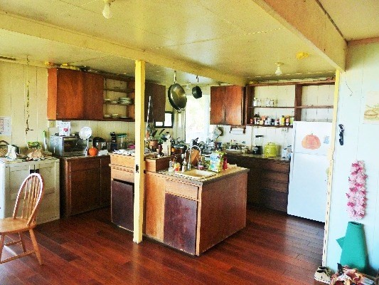 84-1127 Bruner Road Captain Cook, HI 96704 - Photo 20 of 25 a kitchen with kitchen island wooden floors and stainless steel appliances