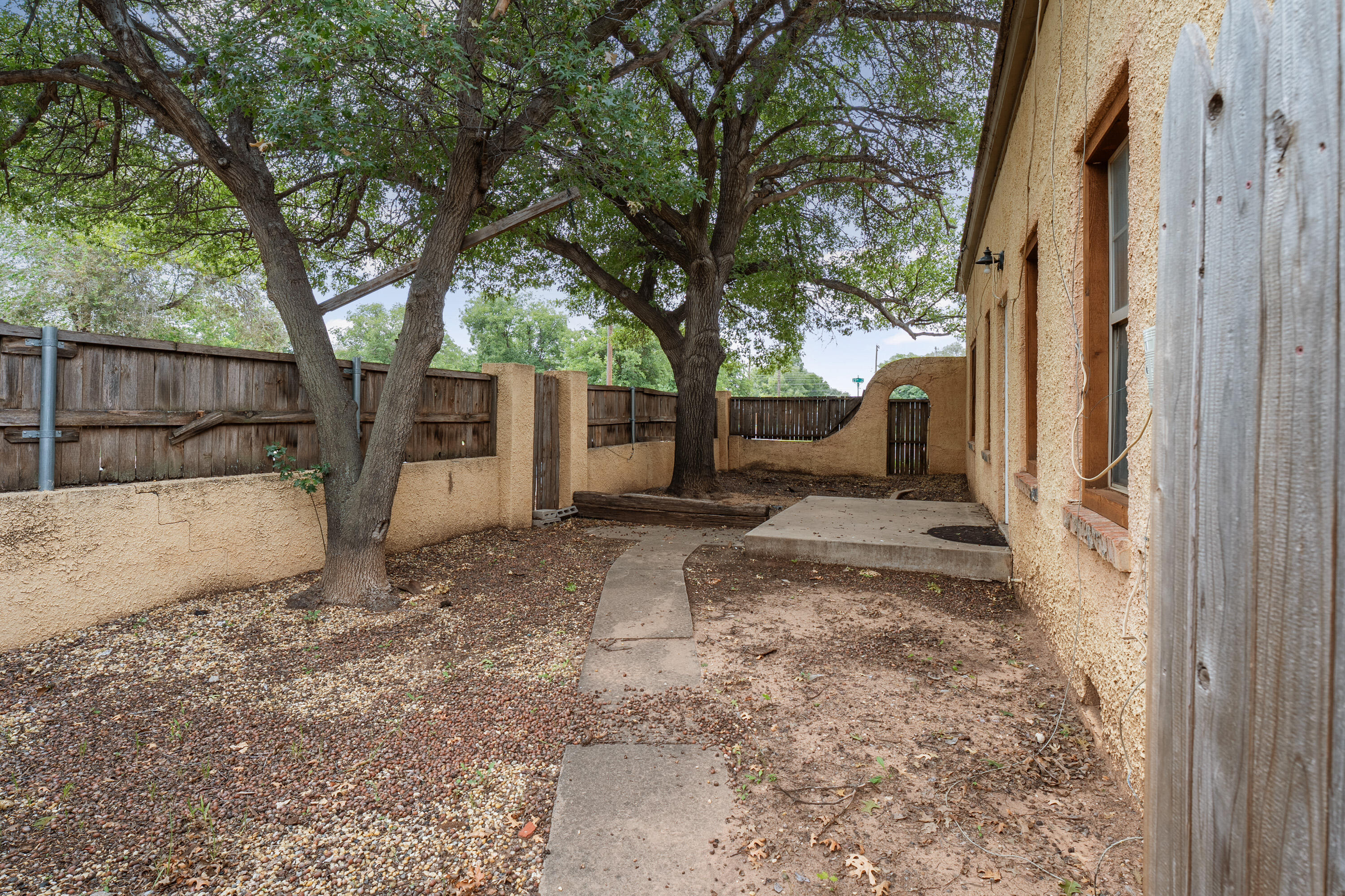 2702 23rd Street Lubbock, TX 79410 - Photo 19 of 30 a view of a backyard with large tree and wooden fence