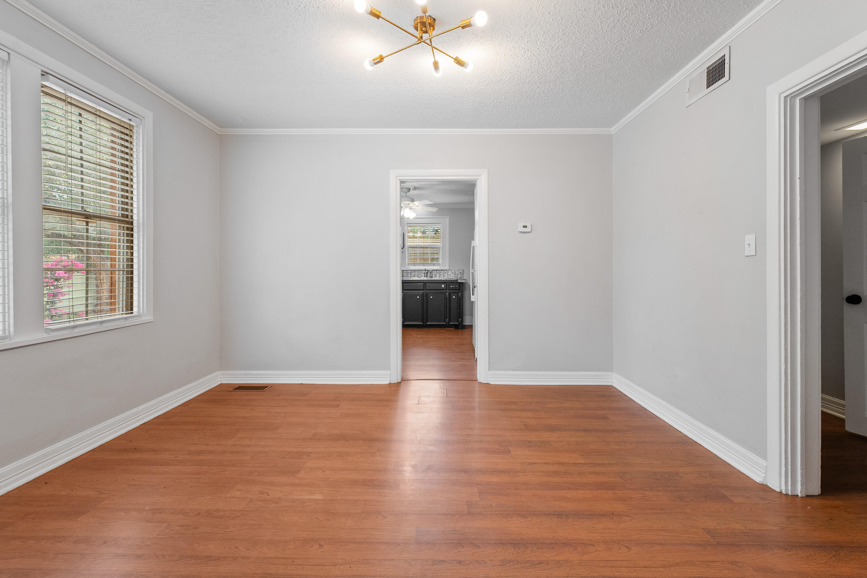 2702 23rd Street Lubbock, TX 79410 - Photo 8 of 30 a view of an empty room with wooden floor and a window