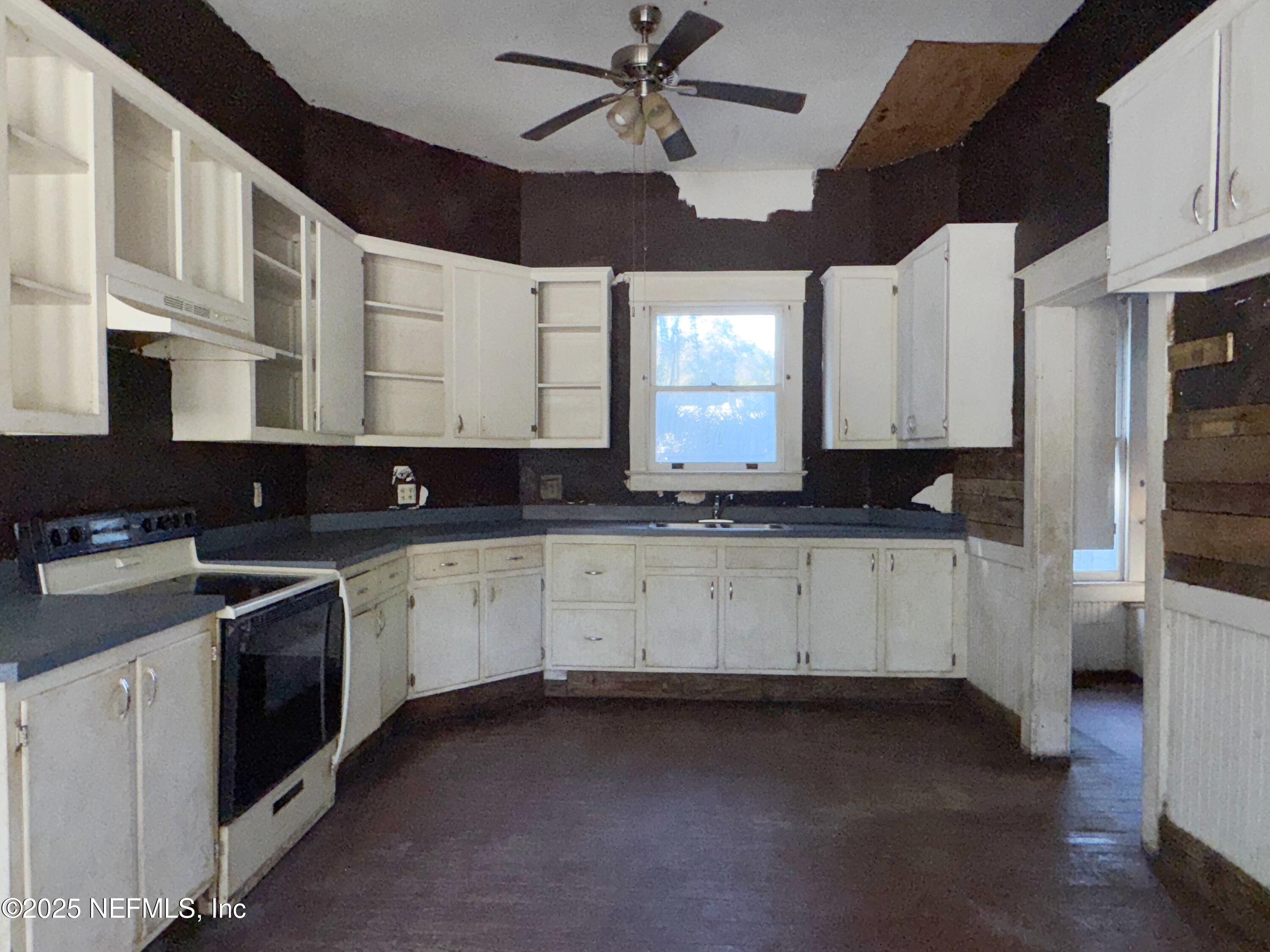 225 Lake George Road Seville, FL 32190 - Photo 18 of 37 a kitchen with granite countertop white cabinets white appliances a sink and a window