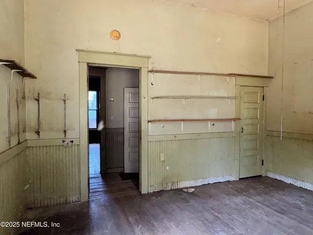 an empty room with windows and chandelier fan