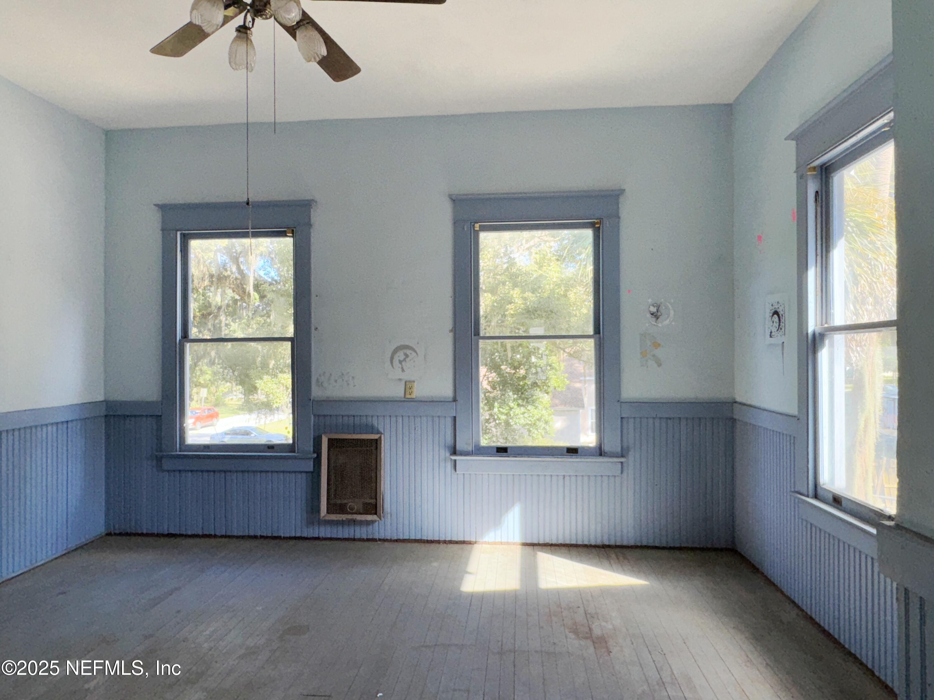 225 Lake George Road Seville, FL 32190 - Photo 24 of 37 an empty room with windows and chandelier fan