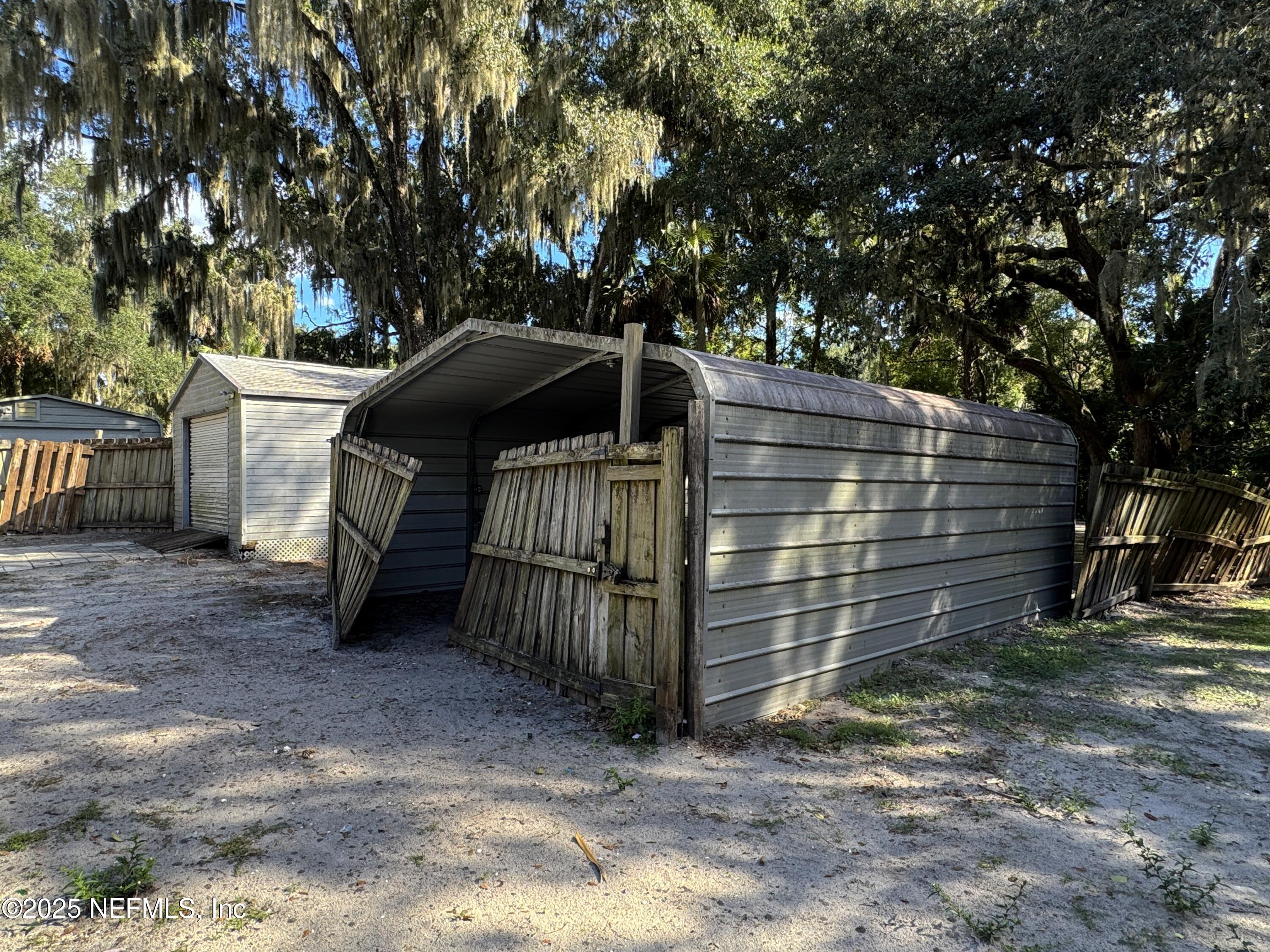 225 Lake George Road Seville, FL 32190 - Photo 36 of 37 a view of a wooden house with a large tree and wooden fence