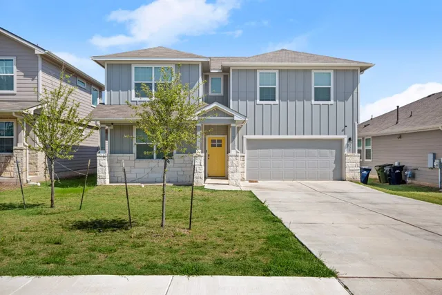 a front view of a house with a yard and garage