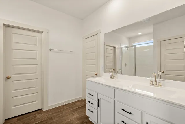 a bathroom with a double vanity sink a mirror and a bathtub