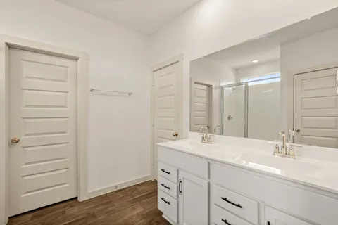 a bathroom with a double vanity sink a mirror and a bathtub