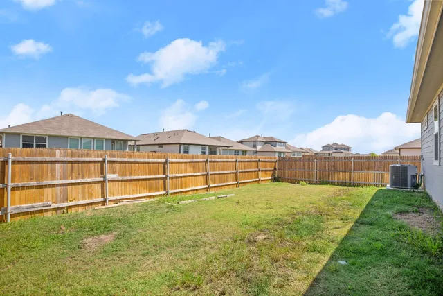 a backyard of a house with barbeque oven table and chairs