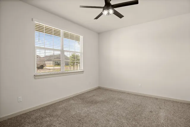 a view of a livingroom with a ceiling fan and window