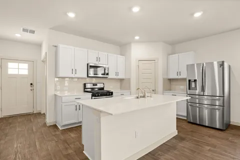 a kitchen with white cabinets and stainless steel appliances