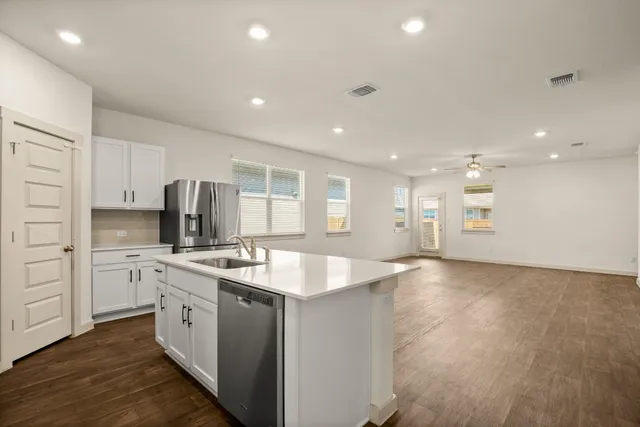 a large kitchen with stainless steel appliances granite countertop a sink and a stove