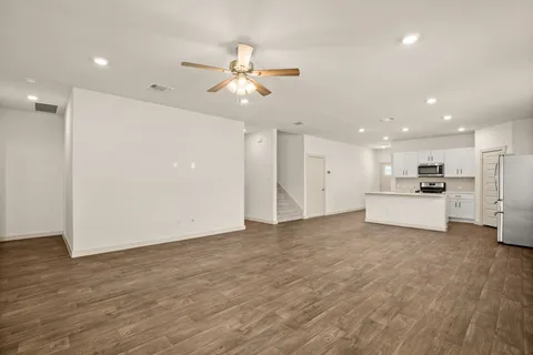a view of a kitchen with a sink dishwasher refrigerator and white cabinets