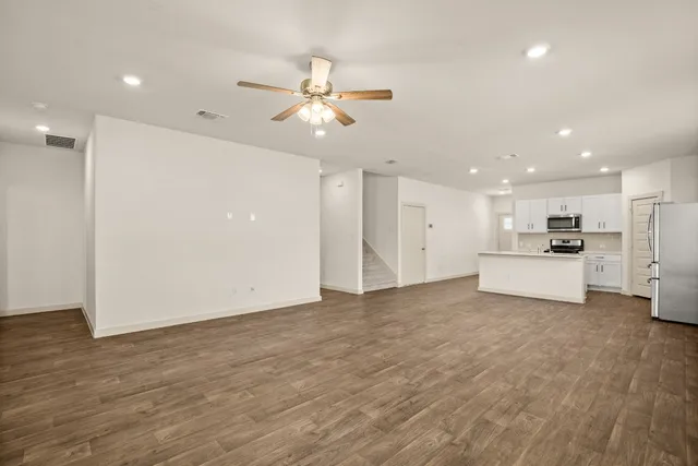 a view of a kitchen with a sink a refrigerator and a stove top oven