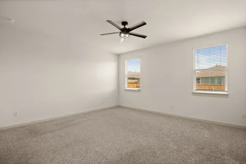 an empty room with a window and a ceiling fan