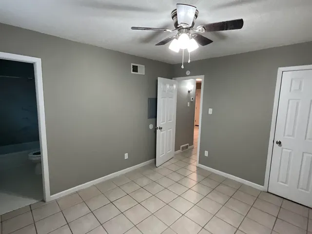 an empty room with fan and entrance
