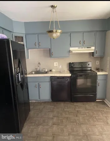 a kitchen with stainless steel appliances a stove a sink and a refrigerator