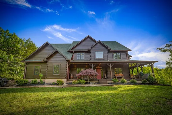 a kitchen with stainless steel appliances granite countertop a stove a refrigerator a sink a dining table and chairs with wooden floor