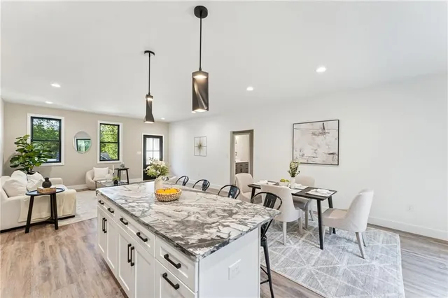 a kitchen with stainless steel appliances granite countertop sink stove and wooden floor