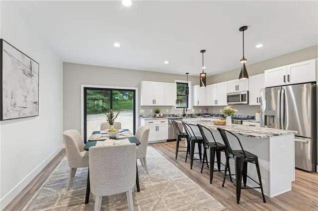 a kitchen with appliances a table and chairs in it