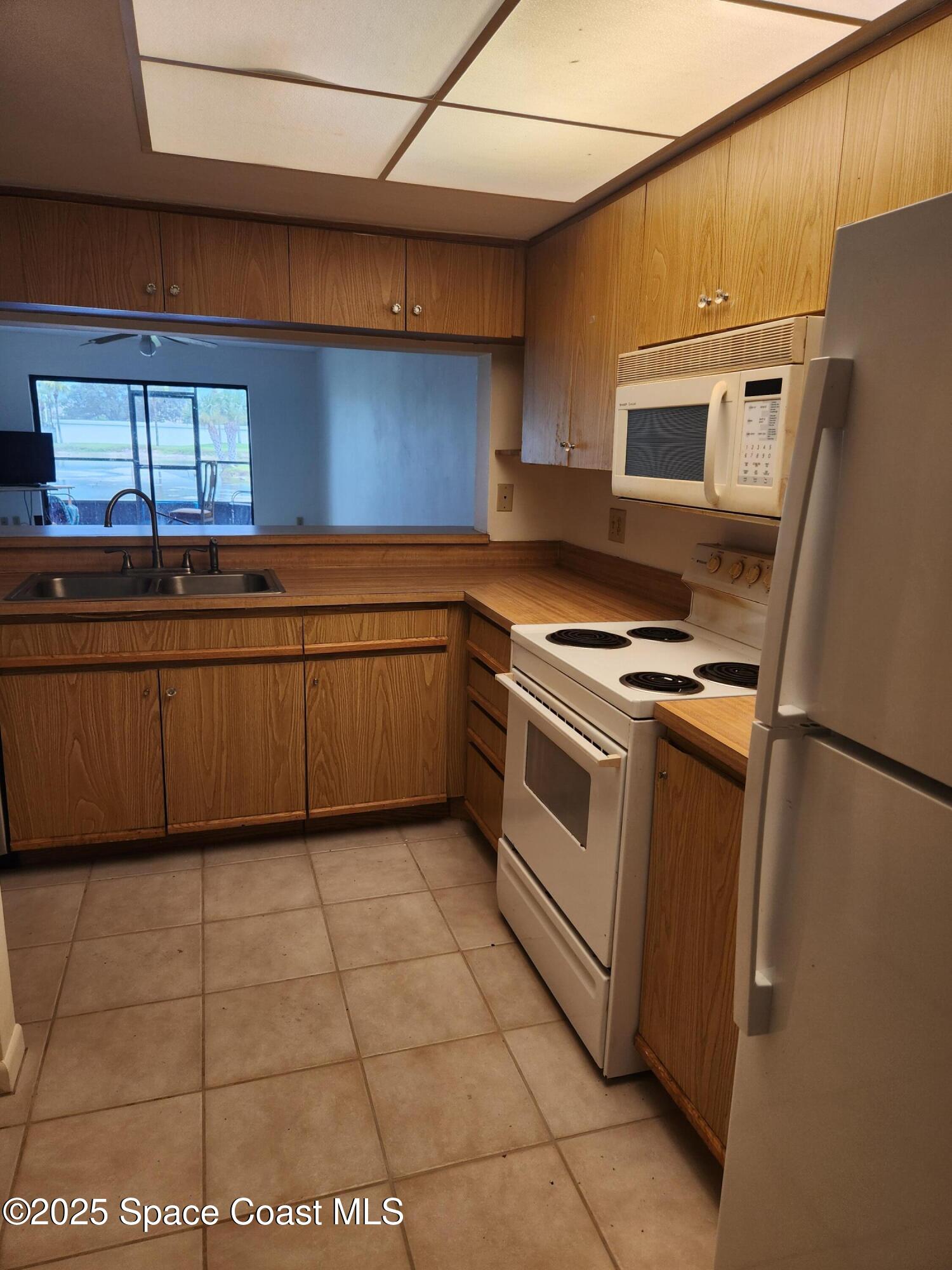3165 North Atlantic Avenue, Unit C105 Cocoa Beach, FL 32931 - Photo 5 of 10 a kitchen with stainless steel appliances granite countertop a sink stove and refrigerator