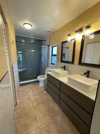 a bathroom with a double vanity sink toilet and shower