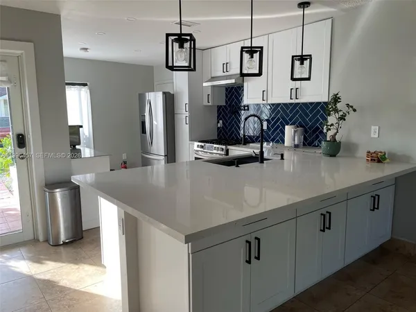 a kitchen with stainless steel appliances granite countertop a sink and refrigerator